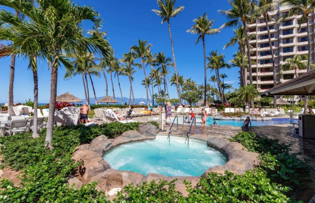 Stunning view of an all inclusive resort in Hawaii with oceanfront and palm trees.