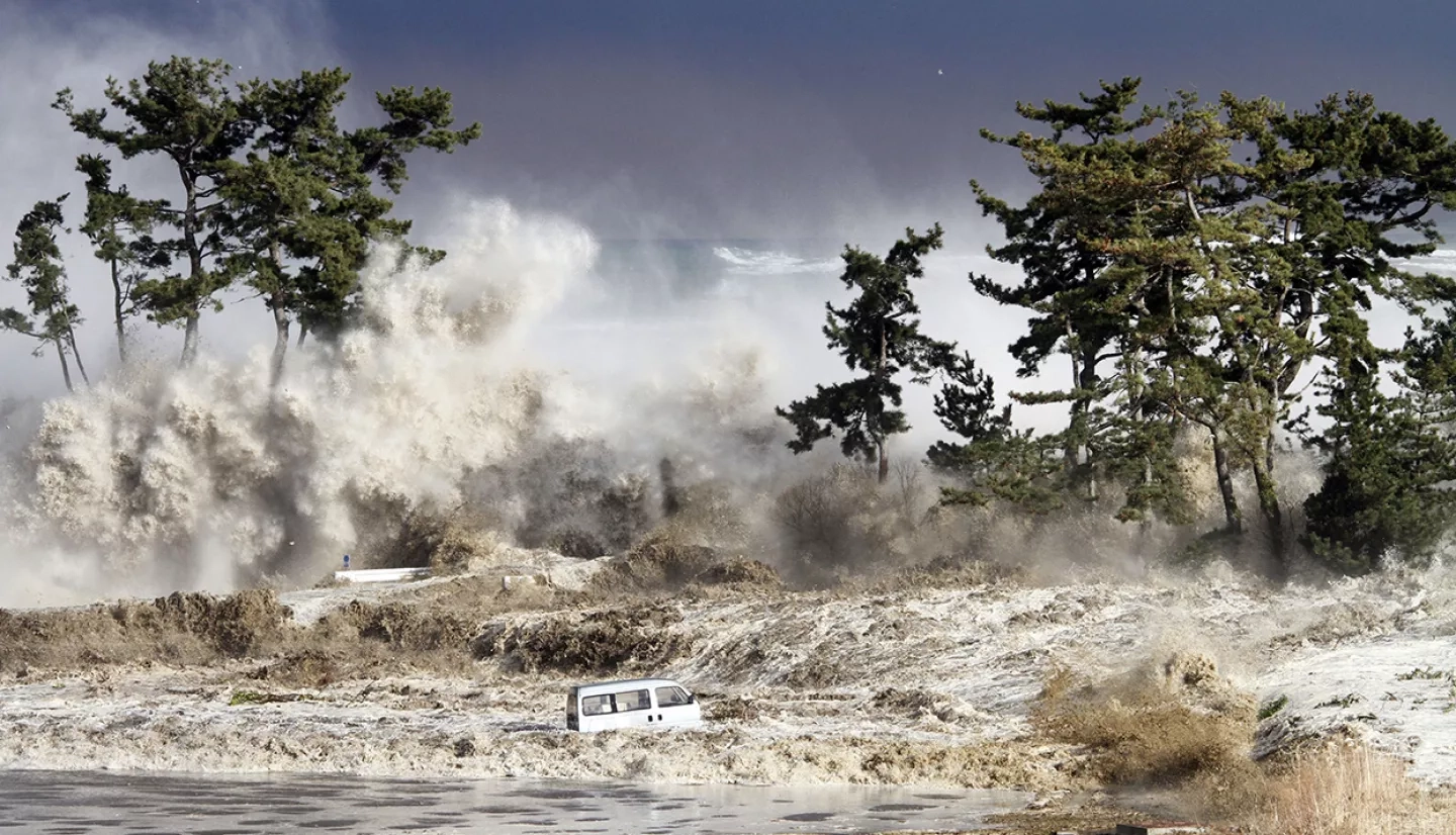 A dramatic view of the ocean waves crashing against the shore in Hawaii, emphasizing the power of tsunamis.