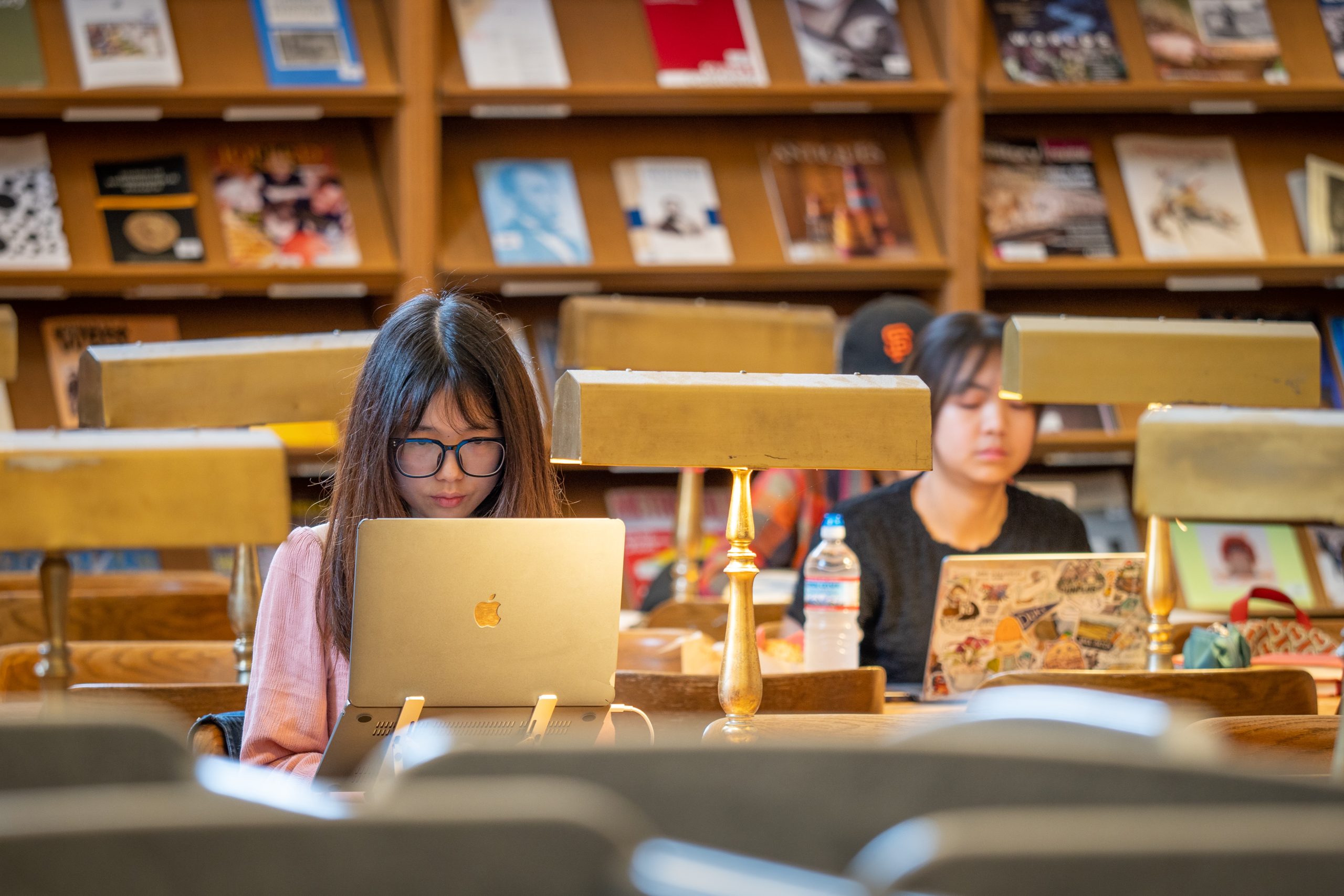 A student using Infinite Campus on a laptop, surrounded by books and school supplies.