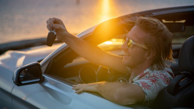 Scenic view of a rental car parked along the beautiful coastline of Kona, Hawaii.