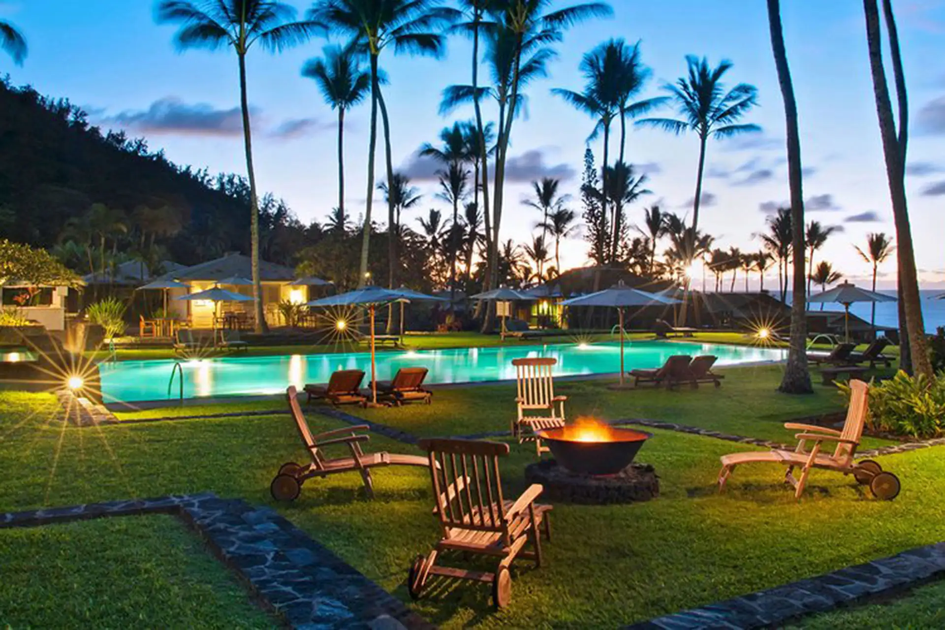 A beautiful beachfront view of an all-inclusive resort in Hawaii with palm trees and clear blue water.